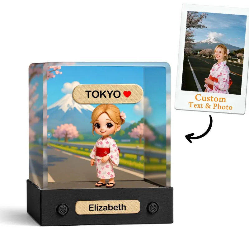 Toy figure of a girl in a kimono with 'Tokyo' and cherry blossoms in the background, featuring a customizable text and photo option.