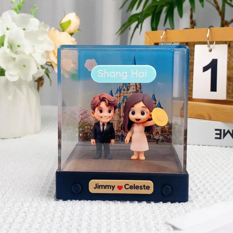 Figurines of a man and woman in formal attire with a castle background, labeled 'Shang Hai', on a white surface with flowers and a calendar in the background.