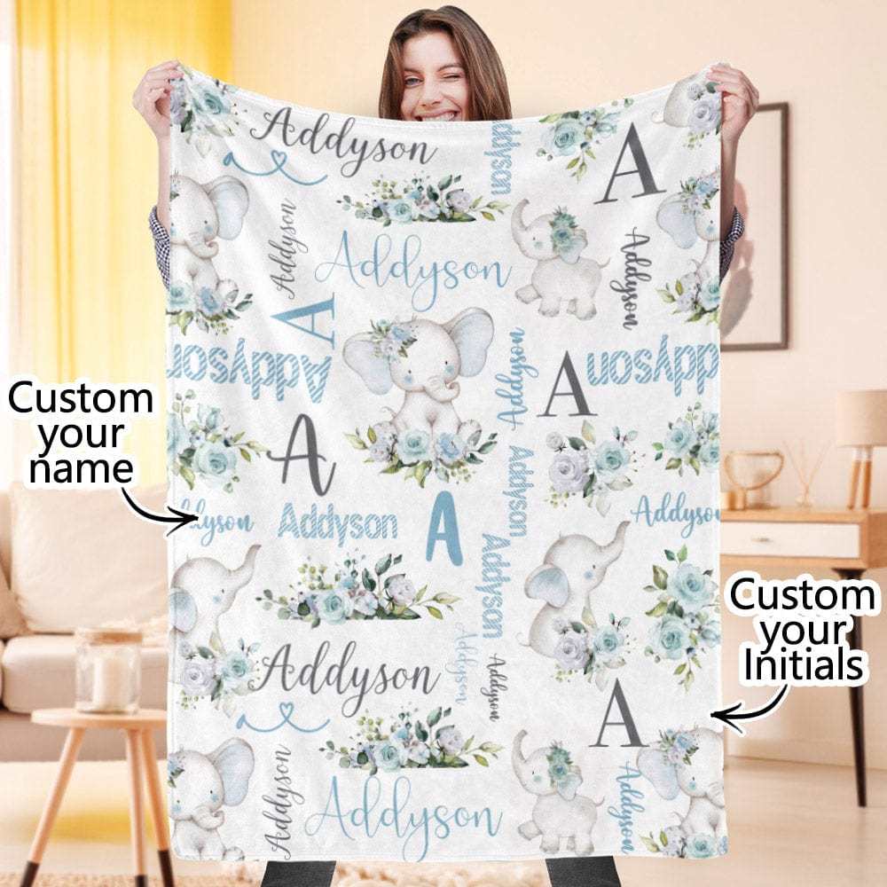 Person holding a personalized blanket with elephant designs and text in a room.