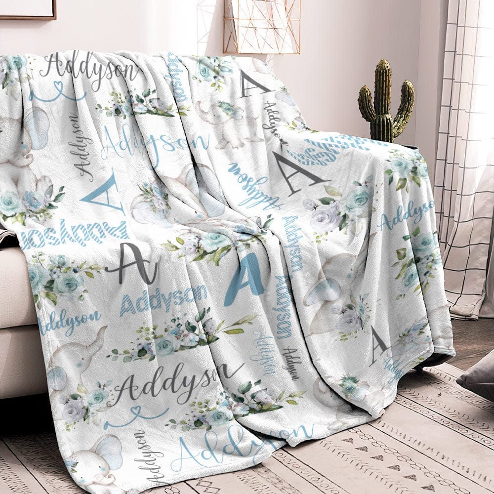 Floral and elephant patterned blanket with 'Addyson' text draped over a chair in a room.