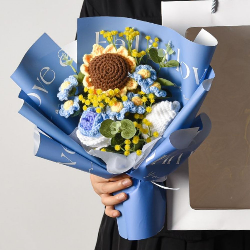 Bouquet of flowers wrapped in blue paper with 'LOVE' text, held by a person.