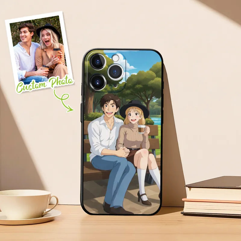 Phone case with cartoon couple design on a wooden surface with a cup and books.