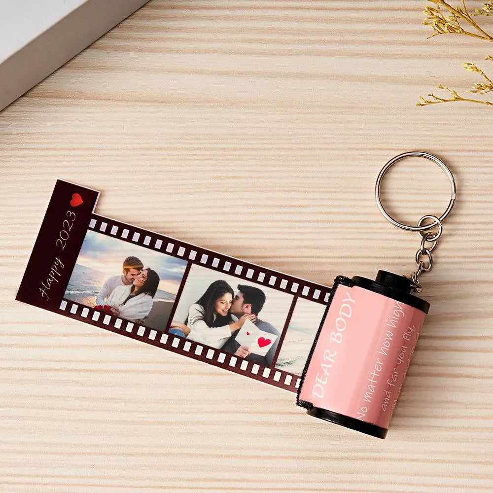 Personalized keychain with photo strip and text on a wooden surface