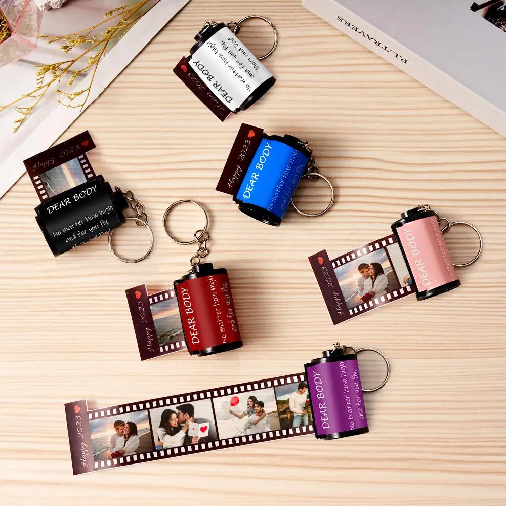Film strip keychains with various designs on a wooden surface