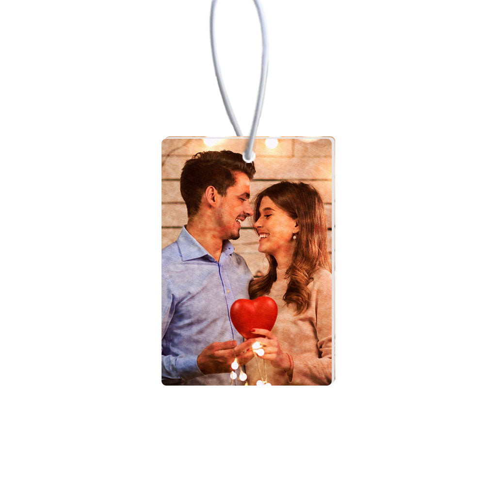Personalized photo ornament with a couple holding a heart-shaped object on a white background