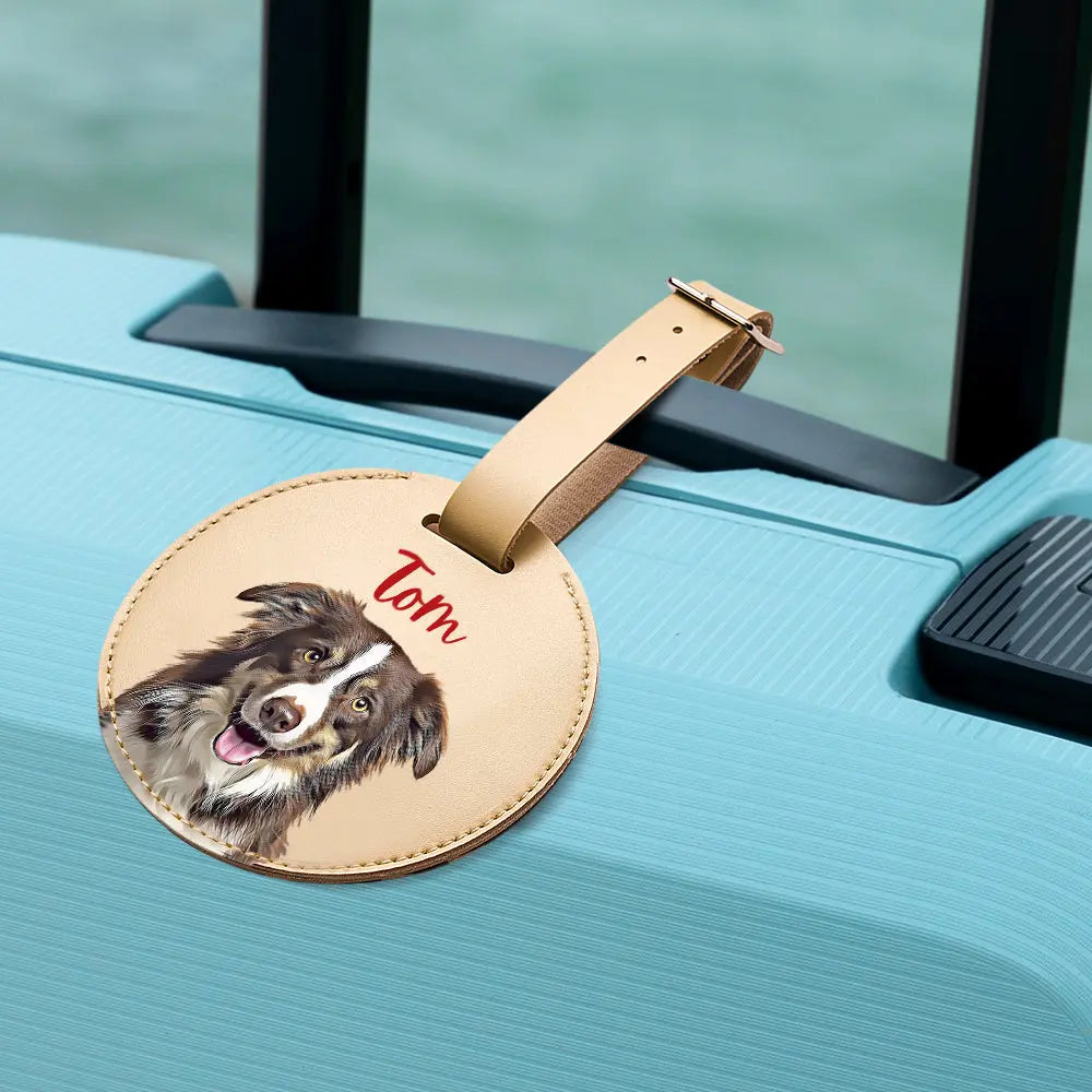 Round leather luggage tag with a dog illustration and 'Tom' text on a suitcase.