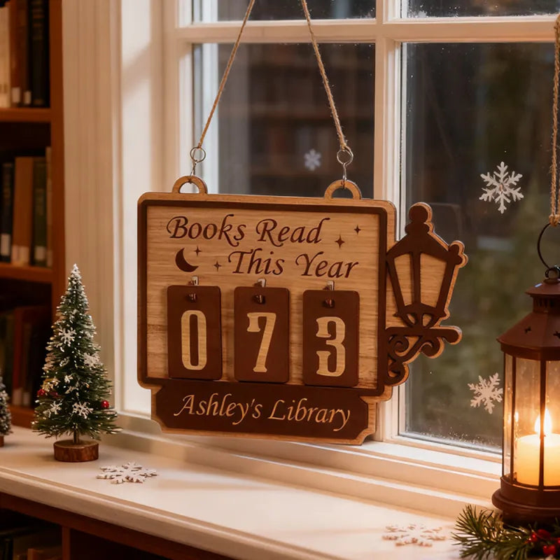 Wooden plaque with 'Books Read This Year' counter hanging by a window with decorative elements.