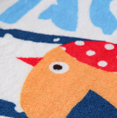 Close-up of a colorful children's rug with a fish design.