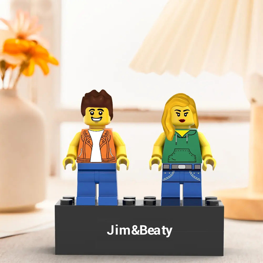 Two LEGO figures on a stand with 'Jim&Beaty' branding, set against a blurred indoor background.