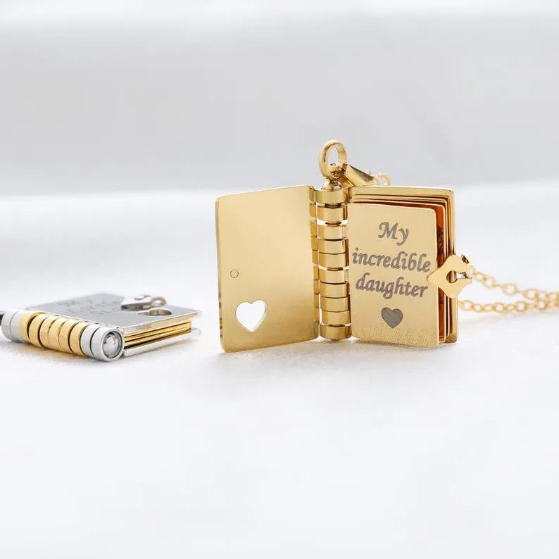 Gold necklace with a book-shaped pendant on a white background