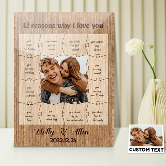 Wooden puzzle with engraved text and a couple's photo, placed on a surface with a white flower in the background.