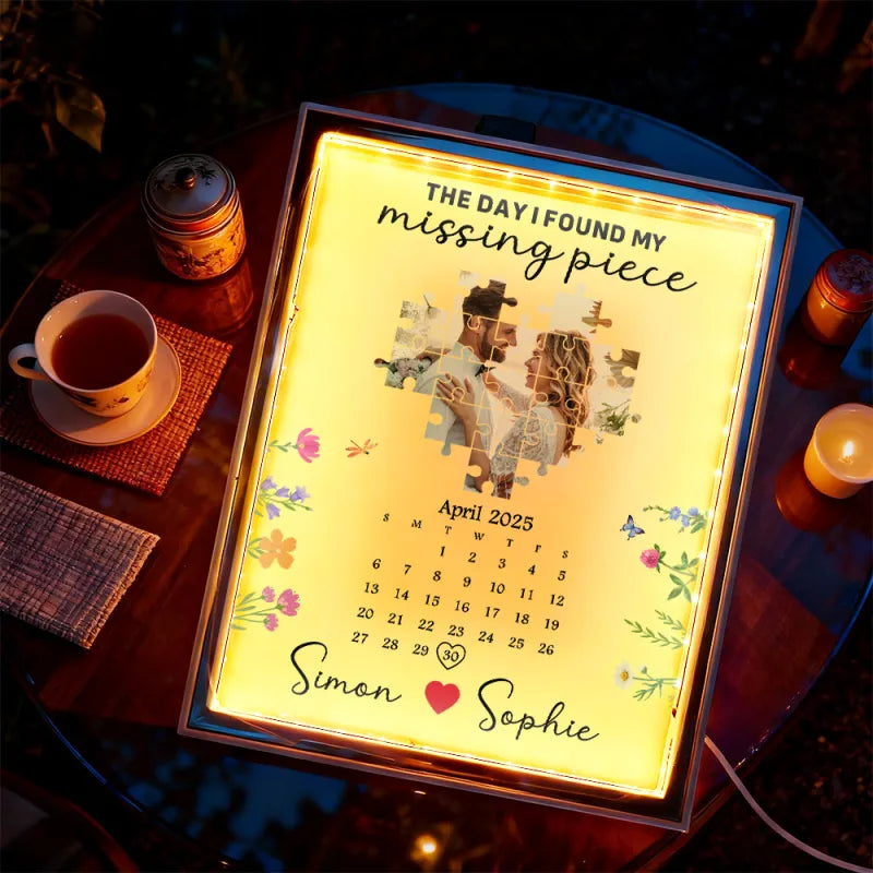 Lighted sign with a puzzle piece design and text on a table with a cup of tea and candles.