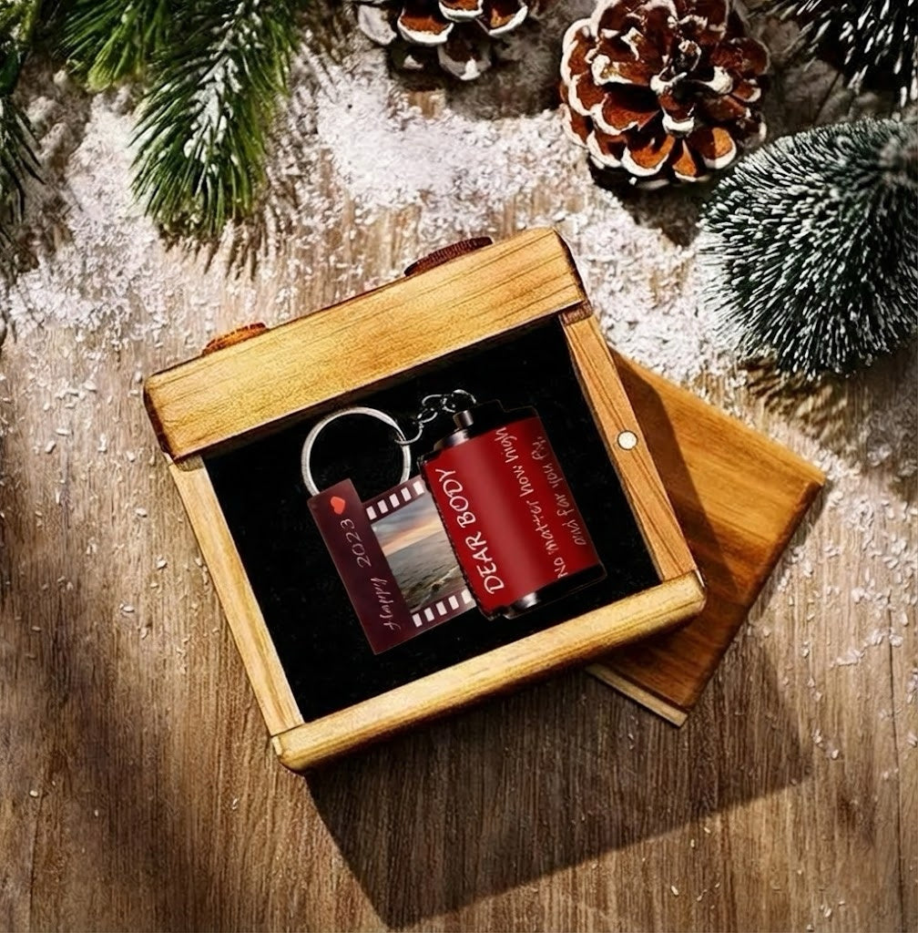 Two keychains in a wooden box with Christmas decorations around