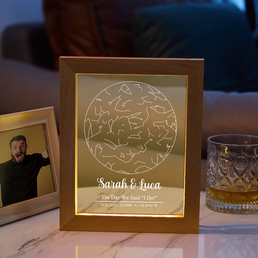 Wooden photo frame with engraved design and text on a table with a glass of whiskey.