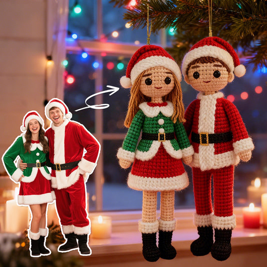 Crocheted Christmas ornaments of a couple in front of a decorated Christmas tree.