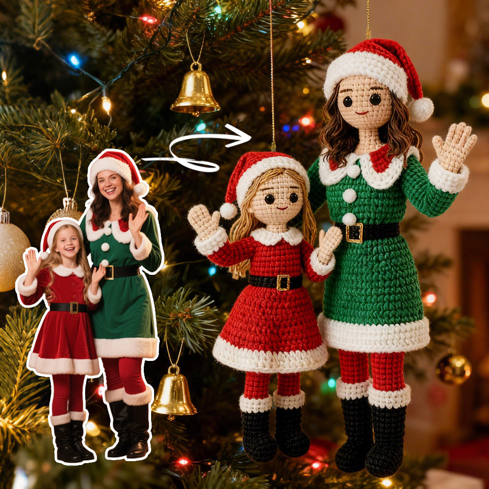 Crocheted Christmas ornaments of a family in festive outfits hanging on a decorated tree.