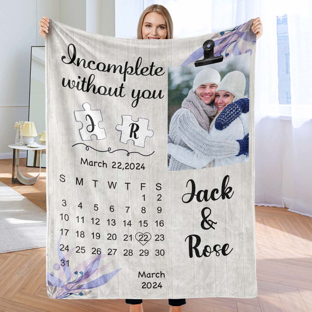 Person holding a blanket with a personalized design, including a photo of a couple and text.