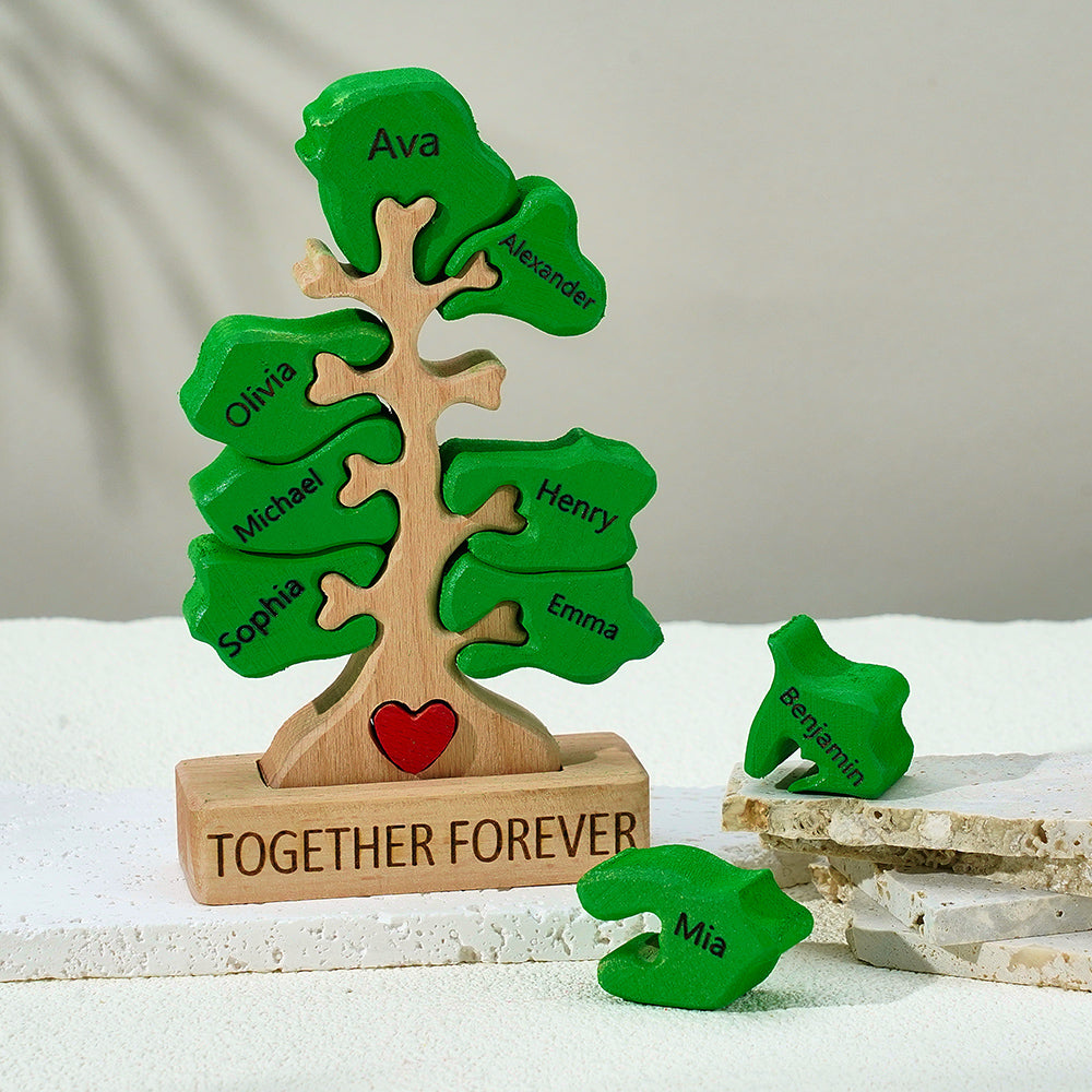 Personalized wooden tree with names on green leaves and a red heart, set against a neutral background.