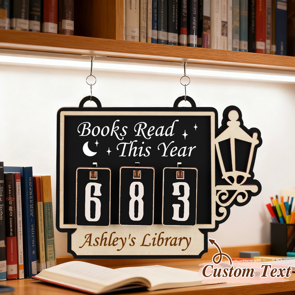Flip clock-style sign with 'Books Read This Year' and 'Ashley's Library' on a bookshelf background.