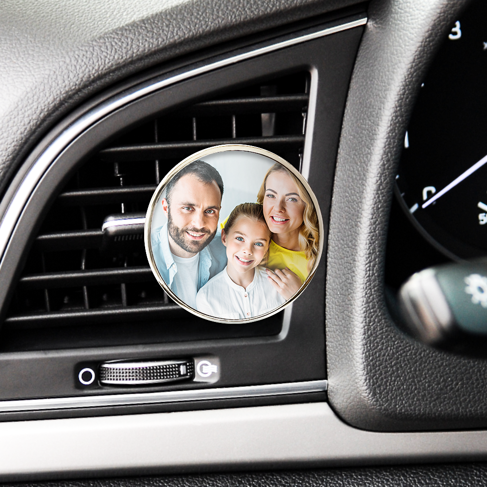 Car air freshener with a family photo attached to it, placed inside a car.