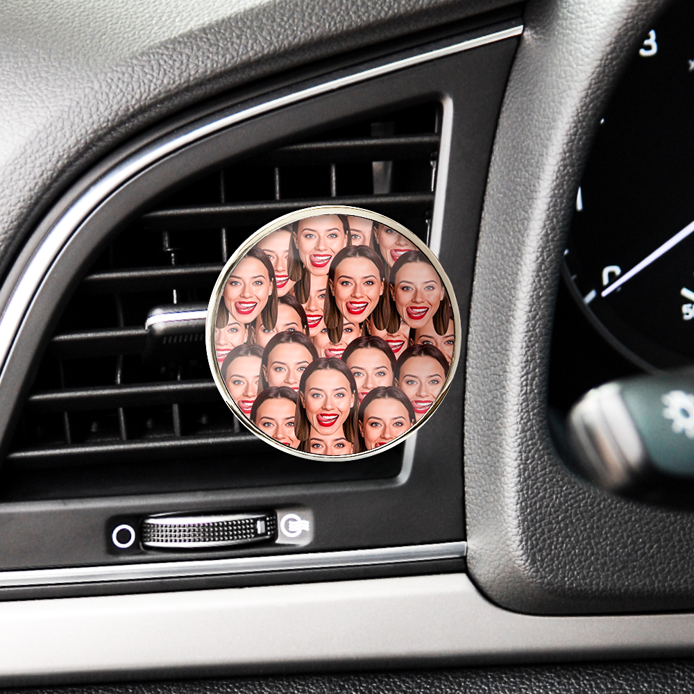 Car air freshener with multiple images of a woman's face on it, placed inside a car's air vent.