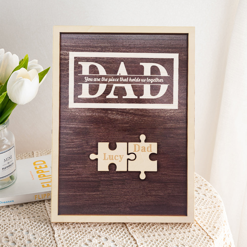 Wooden frame with puzzle piece design and 'DAD' text on a textured surface.