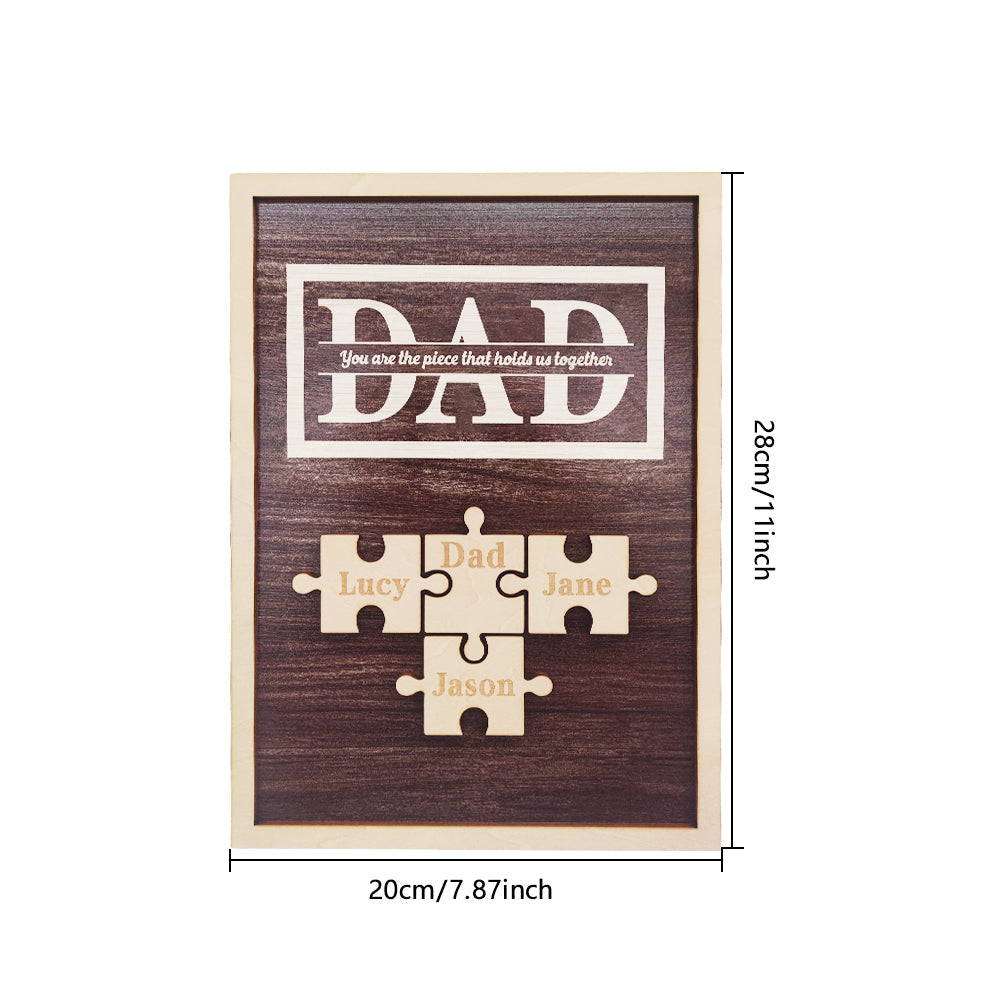 Wooden plaque with puzzle pieces and engraved names on a white background