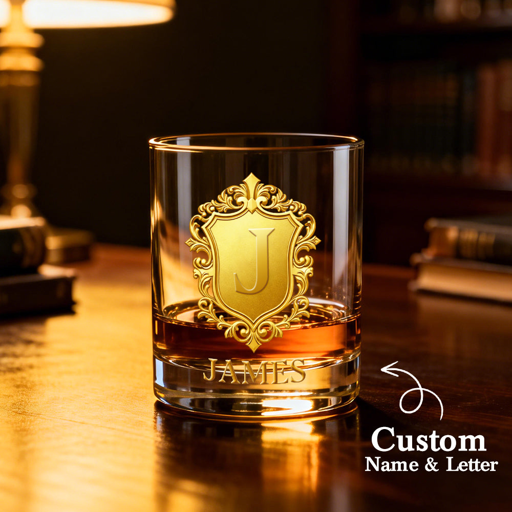 Glass with gold emblem and 'JAMES' text on a wooden surface, with 'Custom Name & Letter' branding.