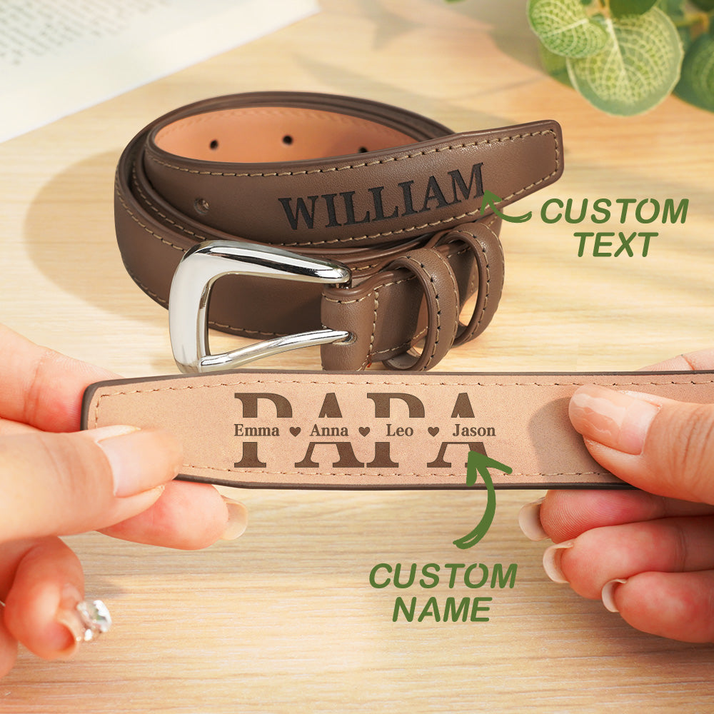 Brown leather belt with engraved text held by hands on a wooden surface