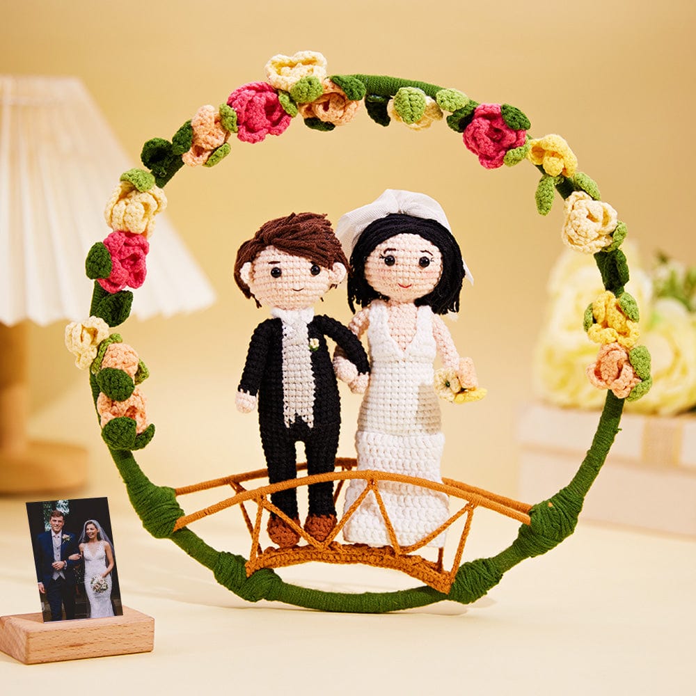 Crocheted wedding couple with a floral arch and bridge on a beige background