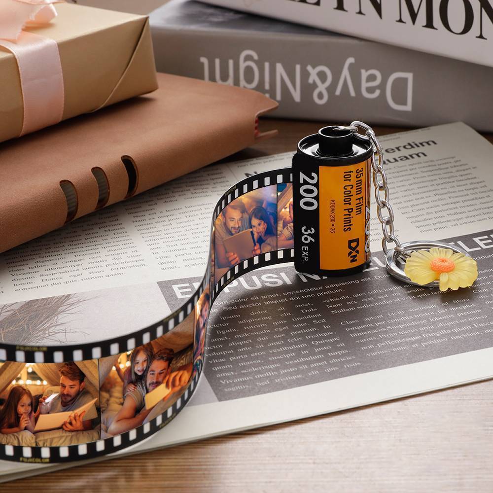 Film reel keychain with photo strip on newspaper
