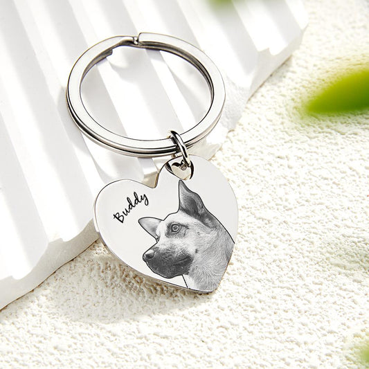 Keychain with heart-shaped tag featuring a dog's photo and name 'Buddy' on a white surface.