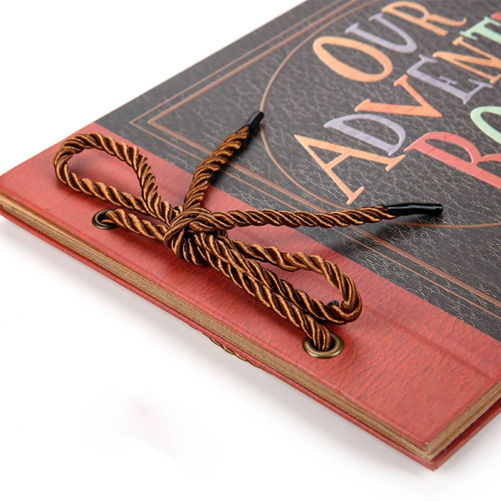 Red book with a decorative rope tied around it on a white background