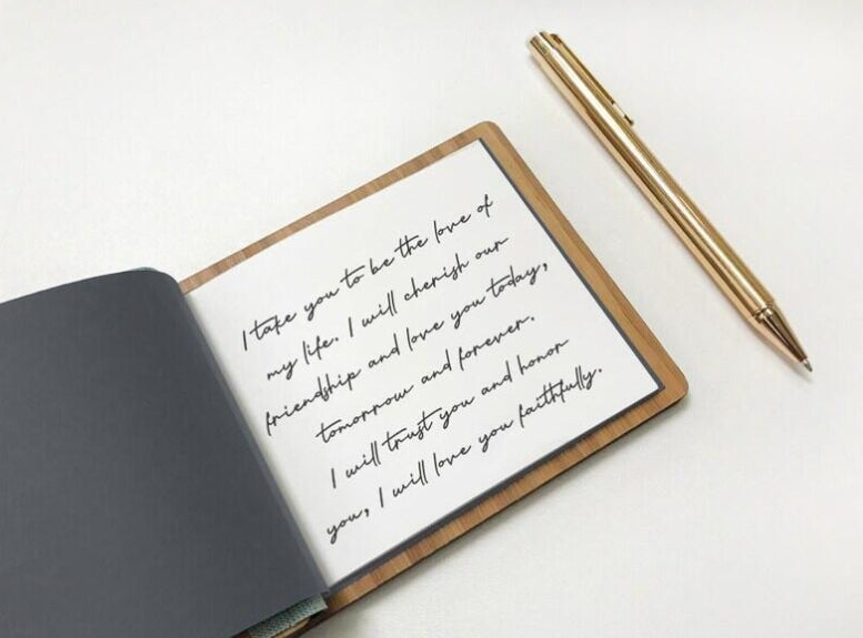 Open notebook with handwritten love letter and gold pen on a white background