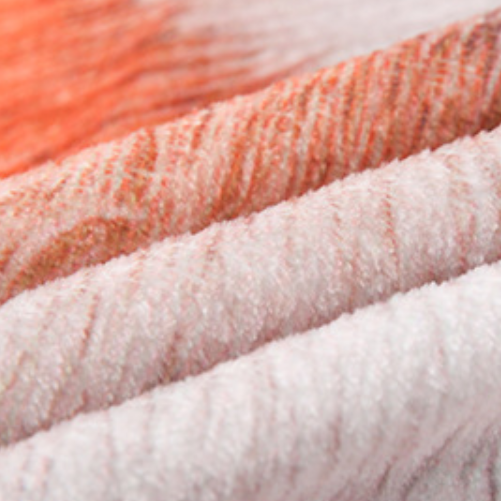 Close-up of three skeins of yarn in orange, white, and pink.