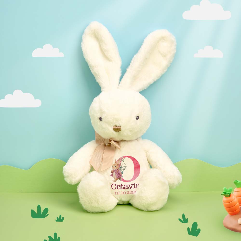 White plush bunny with a pink bow and 'Octavia' tag on a green landscape with clouds