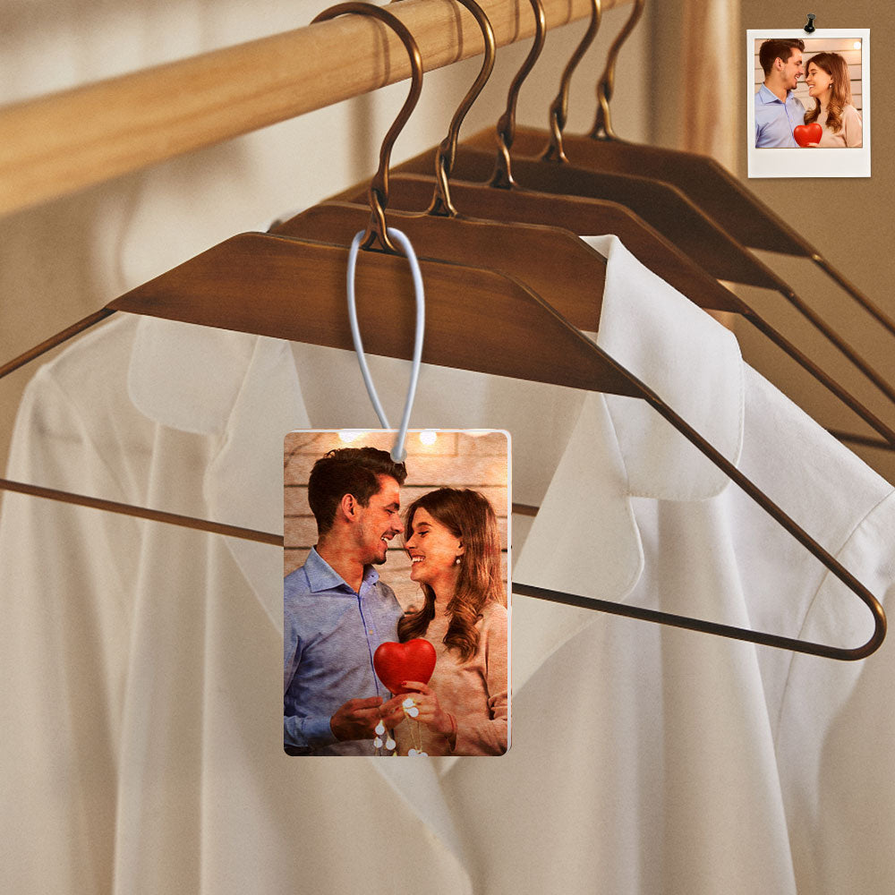Hangers with photo cards of a couple holding a heart, with a blurred background.