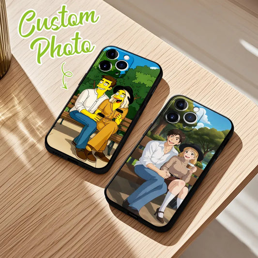 Two phone cases with cartoon-style illustrations of a couple on a wooden surface.