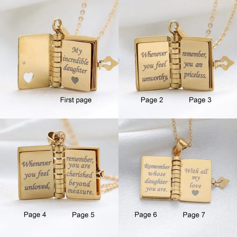 Gold book-shaped pendant with engraved messages on each page, displayed against a white background.
