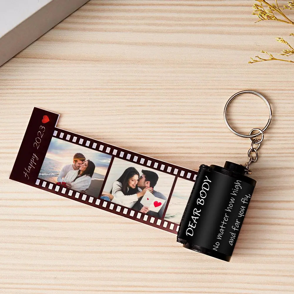 Personalized keychain with photo strip and text on a wooden surface